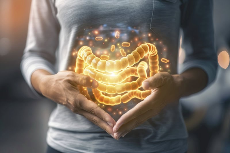 a person with a stomach ache holding their hands